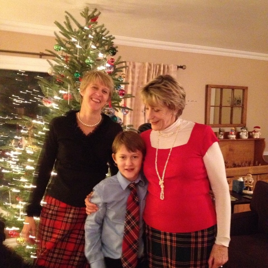 A grandmother, her daughter, and grandson caught in between posing for a Christmas photo.